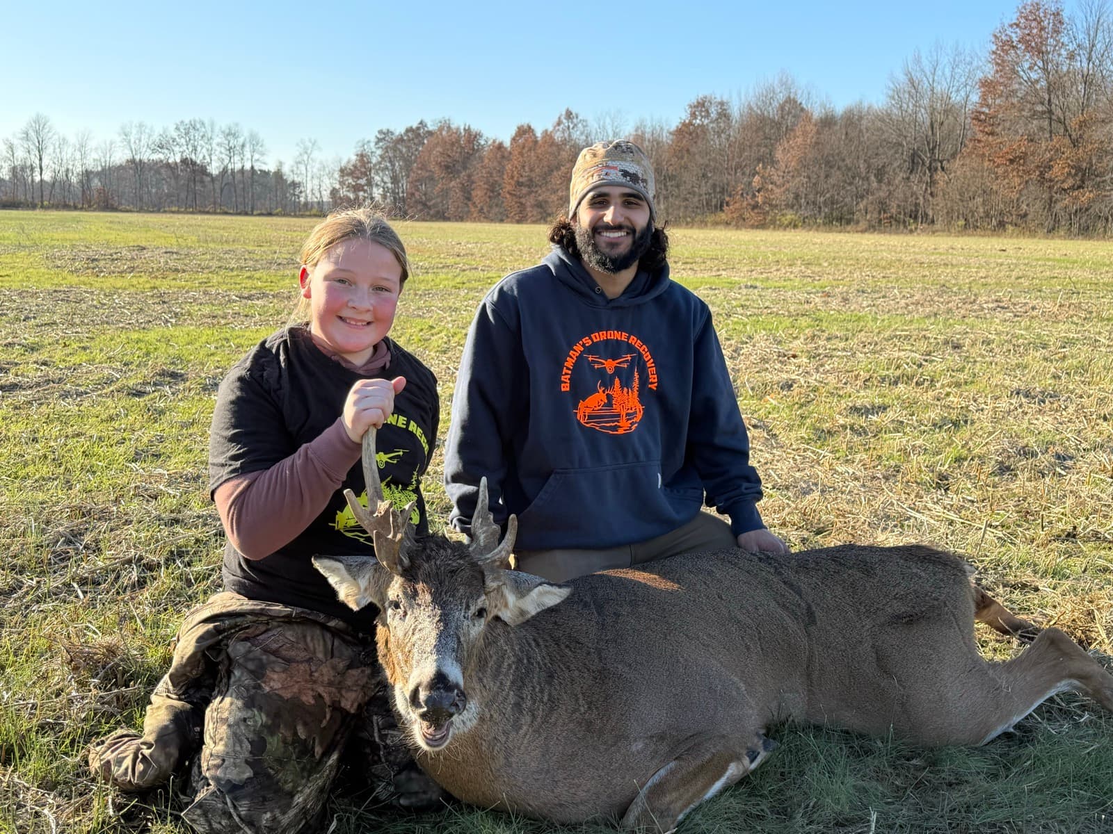 Young hunter's buck recovered in a daylight field