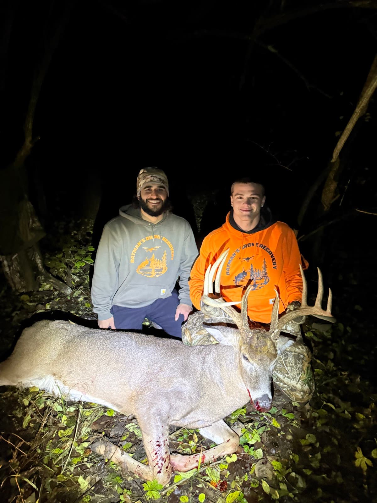 Two hunters with a buck recovered on a night search